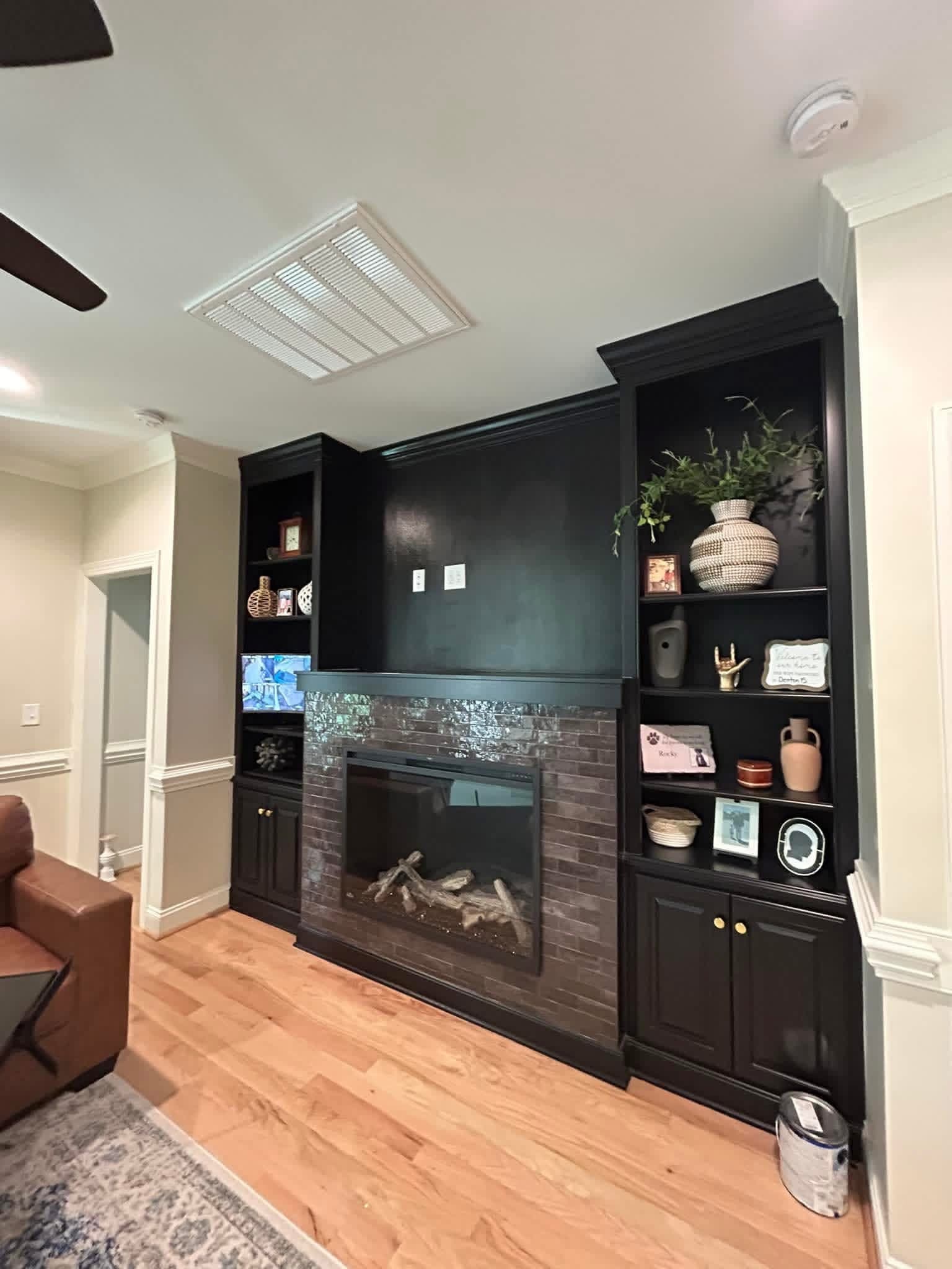 Living room built-in shelving and fireplace surround painted dark by Tacho Painting LLC