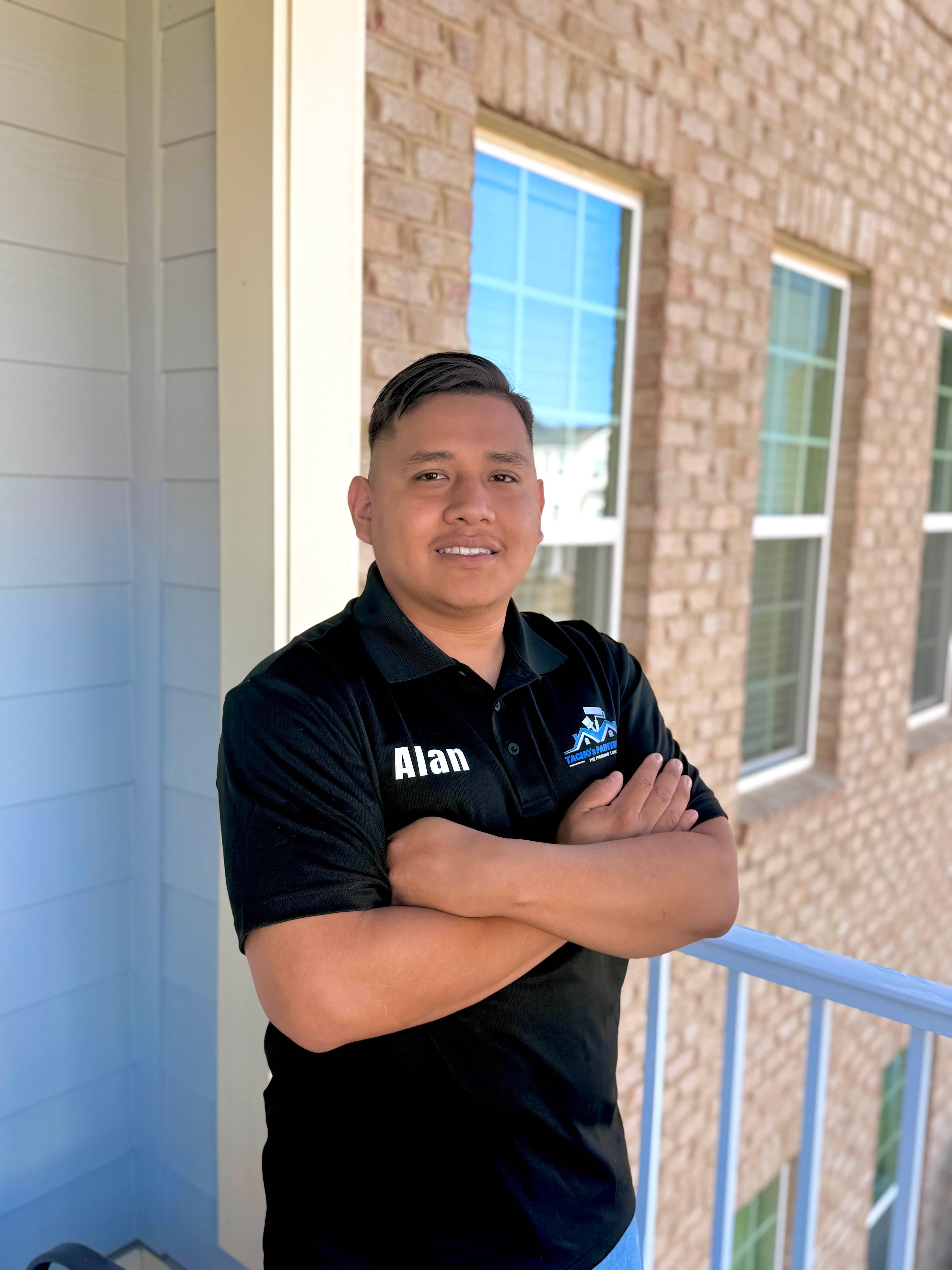Alan Juarez, owner of Tacho Painting LLC, standing in front of a completed project